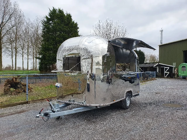 Mobiler Foodtrailer im Airstream-Stil aus Edelstahl, geeignet für Streetfood oder Gastronomie.