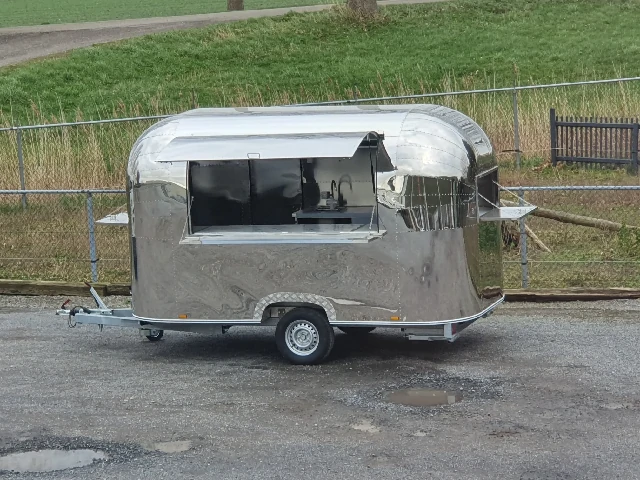 Mobiler Foodtrailer im Airstream-Stil aus Edelstahl, geeignet für Streetfood oder Gastronomie.