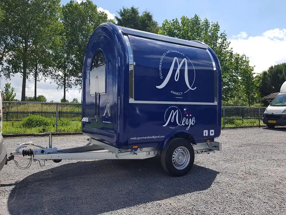 Compact rounded food trailer for mobile vending and catering use.