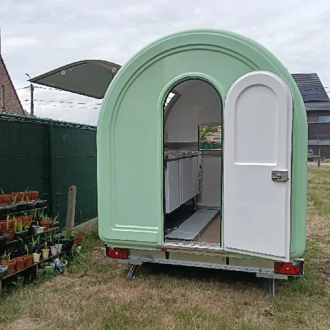 Compact rounded food trailer for mobile vending and catering use.